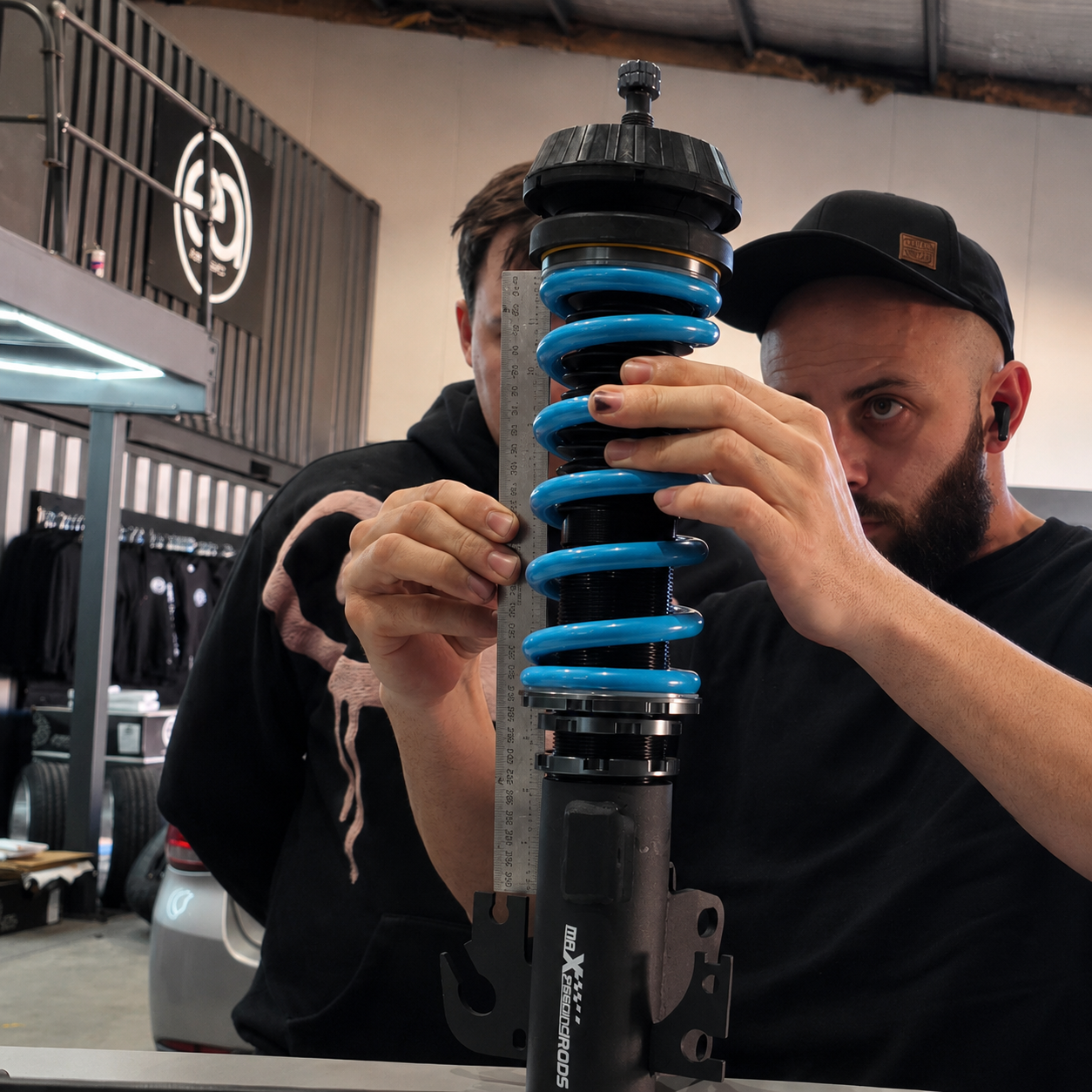 EA Industries checking a coilover during a stance package setup.